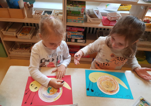 Dziewczynki kolorują ślimaka.