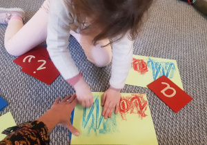 Dziewczynka tworzy napis Maria Montessori.