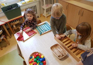 Dzieci działają z montessorińskim materiałem rozwojowym.