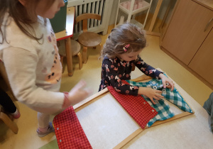 Dziewczynki zapinają guziki.