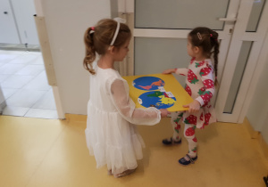 Dziewczynki wynoszą wykonaną pomoc na wystawkę.