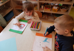 Dzieci kolorują obrazek z wizerunkiem Marii Montessori.