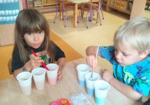 dzieci farbują wodę w kubeczkach