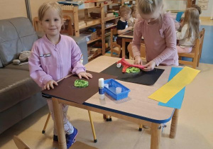 Dzieci siedzą przy stoliku i wykonują pracę plastyczną - ślimaka