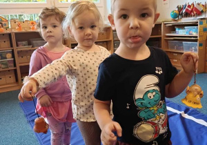 Dzieci idą po elipsie z dzwonkiem w ręku podczas ćwiczenia ciszy