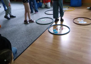 Dzieci segregują odpady układając zdjęcie w obręczy w odpowiednim kolorze