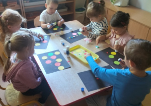 dzieci podczas tworzenia swojej pracy z kropek