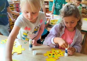 dzieci podczas tworzenia swoich elementów puzzli