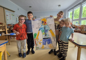 Dzieci prezentują wykonany przez siebie w grupie plakat, na którym znajduje się Mark
