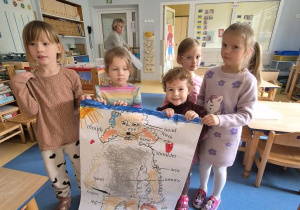 Dzieci prezentują wykonany przez siebie w grupie plakat, na którym znajduje się Dora