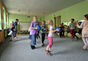 Dzieci biegają z piłkami