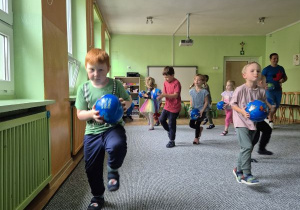 Dzieci biegają z piłkami