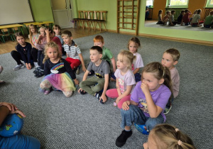 Dzieci siedzą na dywanie