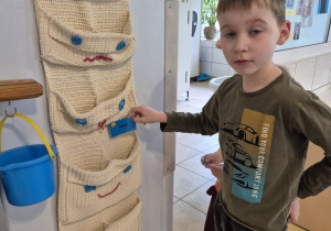 Chłopiec wkłada swoją wizytówkę do kieszonki z uśmiechniętą buźką