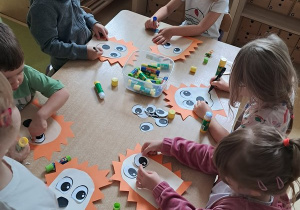 Dzieci w czasie pracy plastycznej wykonują kompozycję jeża z dostępnych materiałów