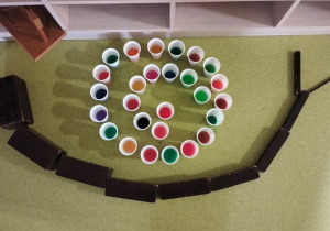 zdjęcie ślimaka z brązowych schodów i kubeczków z farbowaną wodą