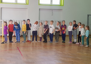 Dzieci stoją ustawione jeden za drugim