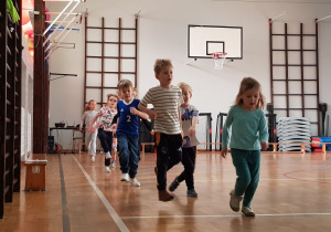 Dzieci podczas biegu rozgrzewkowego dookoła sali