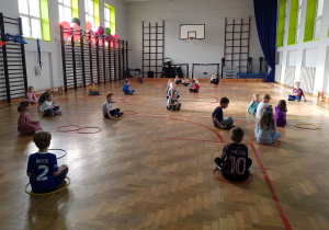 Dzieci siedzą skrzyżnie w obręczach