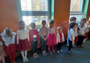 Dzieci przyjmują właściwą postawę do zaśpiewania hymnu