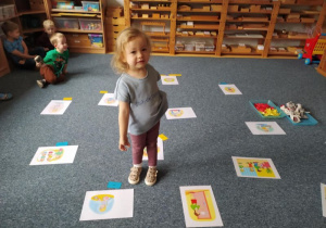 Dziewczynka stoi przy obrazkach przedstawiających prawa dziecka