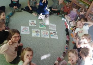 Dzieci siedzą na dywanie wokół serca