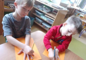 Chłopcy odrysowują swoje ręce