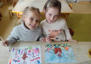 Dziewczynki malują farbami prace plastyczne na temat: ,,Praw dziecka".