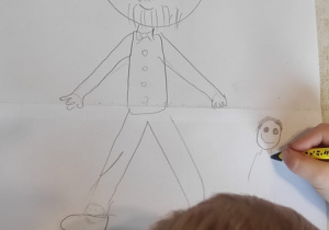 Chłopiec szkicuje postać Janusza Korczaka.