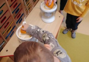 Chłopcy wyciskają sok z pomarańczy