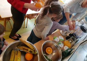 Dzieci przygotowują owocowy koktail