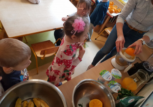 Dzieci przygotowują owocowy koktail