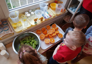 Dzieci przygotowują owocowy koktail