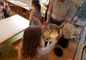 Dziewczynka wkłada banany do naczynia miksującego