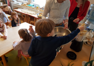 Chłopiec wkłada banany do naczynia miksującego