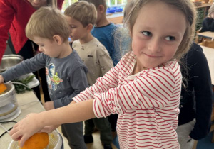 Dziewczynka wyciska sok z pomarańczy