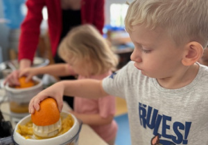 Dzieci wyciskają sok z pomarańczy