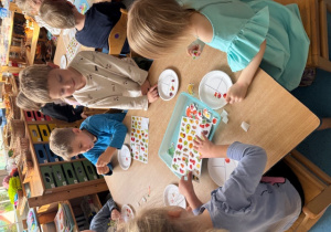 Dzieci przygotowują talerze z naklejkami zdrowych produktów