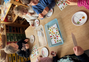 Dzieci przygotowują talerze z naklejkami zdrowych produktów