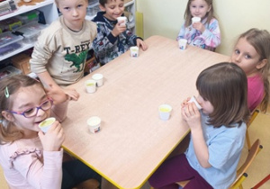 Dzieci siedzą przy stolikach i degustują koktajle