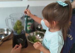 Natalka wkłada owoce do sokowirówki