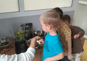 Tymon wkłada owoce do sokowirówki