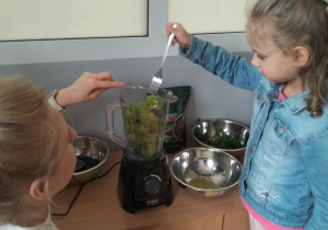 Michasia wkłada owoce do sokowirówki