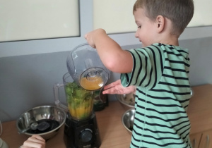 Wiktor wlewa sok z odciśniętych pomarańczy do sokowirówki