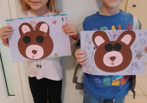 Dzieci pozują do zdjęcia ze swoimi pracami