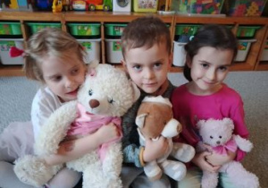 Dzieci pozuja do zdjęcia wraz ze swoimi misiami