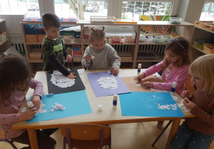 Dzieci wydzieranką wykonują pracę plastyczną z niedźwiedziem polarnym