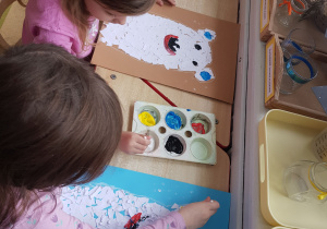 Dziewczynki kończą swoje prace, malując detale farbą plakatową