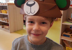 Chłpoiec prezentuje wykonaną przez siebie czapkę