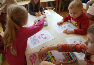 Dzieci kolorują obrazki z misiem